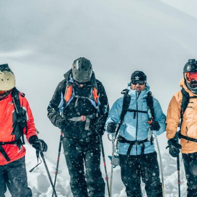 A group of well-equipped skiers navigating snowy terrain during a winter adventure, showcasing vibrant gear and energy.
