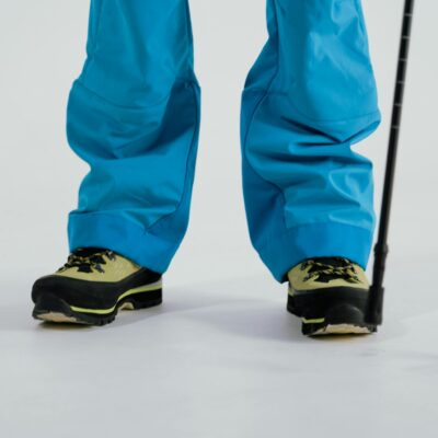 Close-up of winter boots and trekking poles on a snowy surface, ready for adventure.