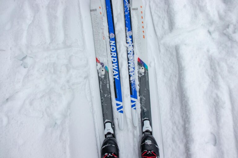 Top view of cross-country skis on a snowy trail in a winter setting, perfect for outdoor sports enthusiasts.